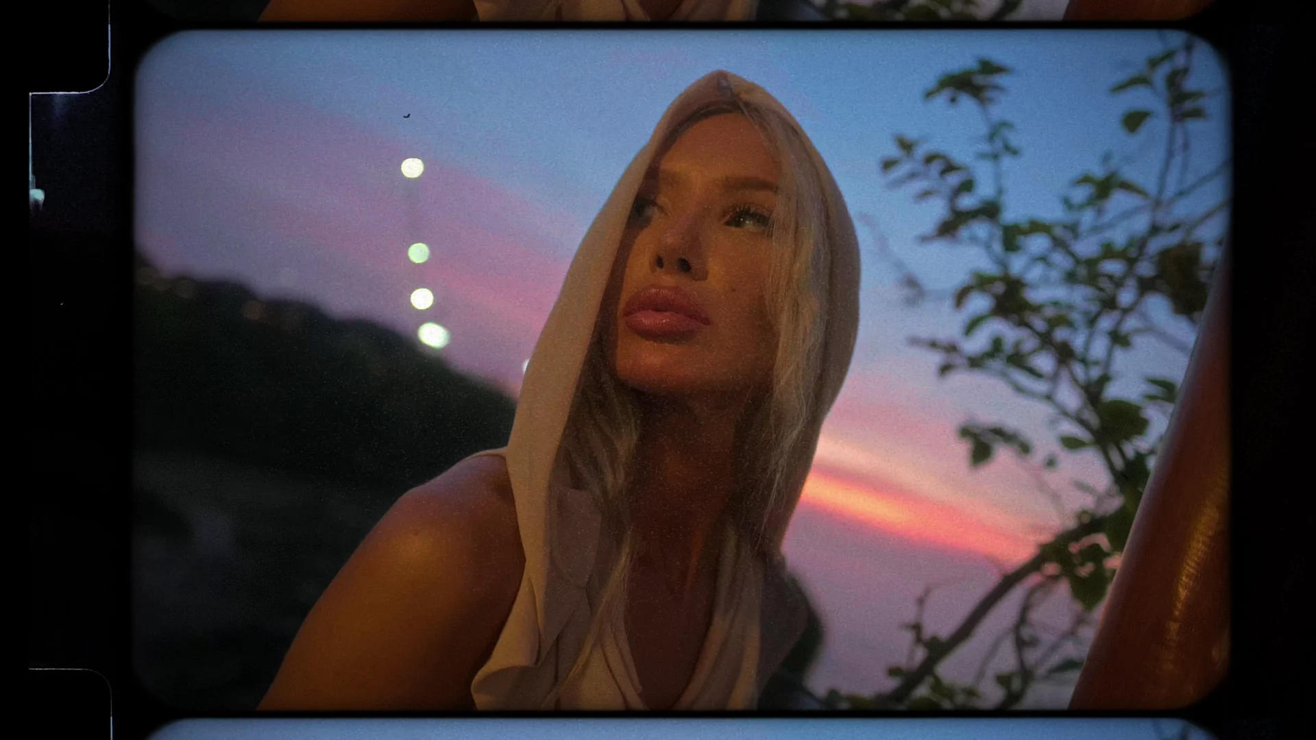 A portrait beside the ocean, moving from warm window light into the blue hour.