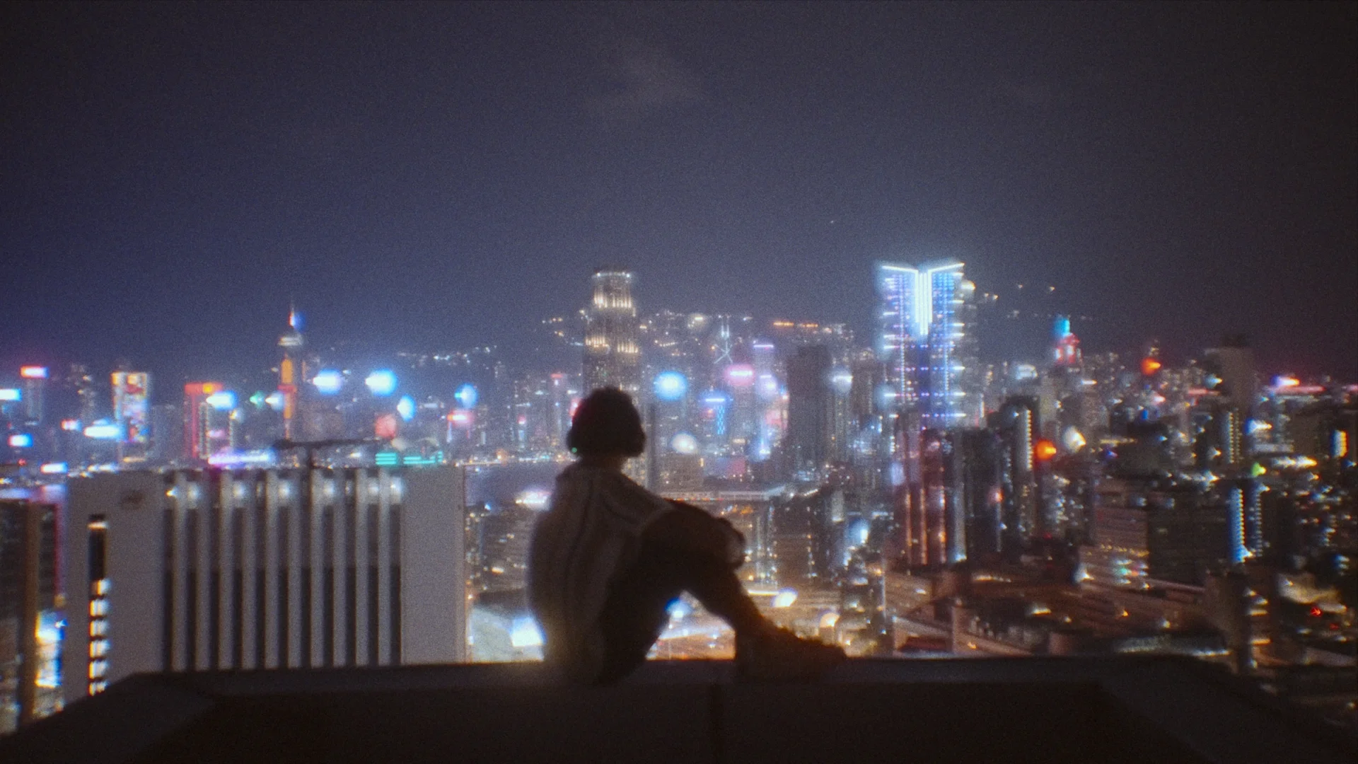 Hong Kong after dark: neon streets, temple light, and the harbour skyline.