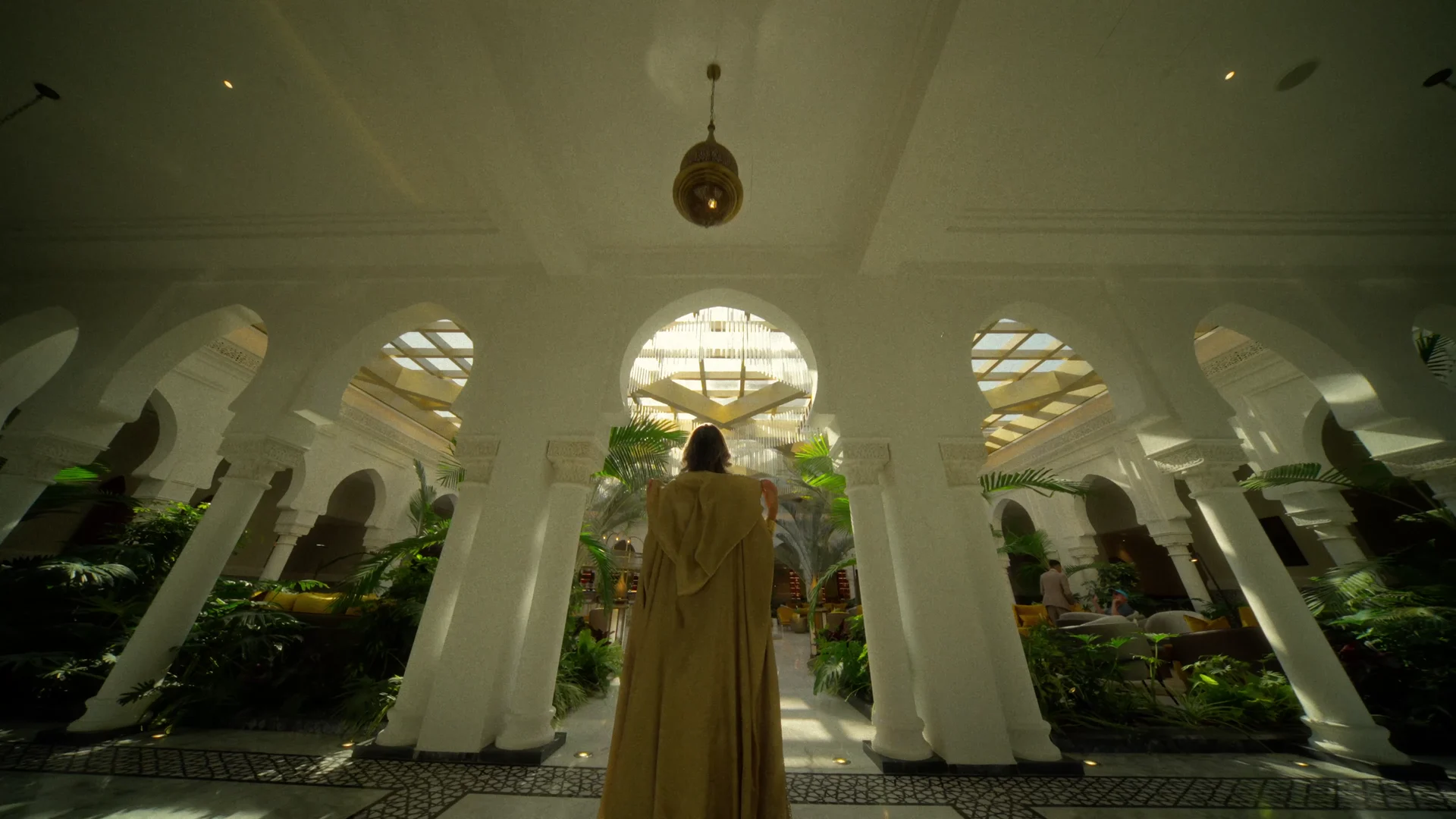 An arrival sequence through landscaped avenues and the hotel's light-filled interiors.